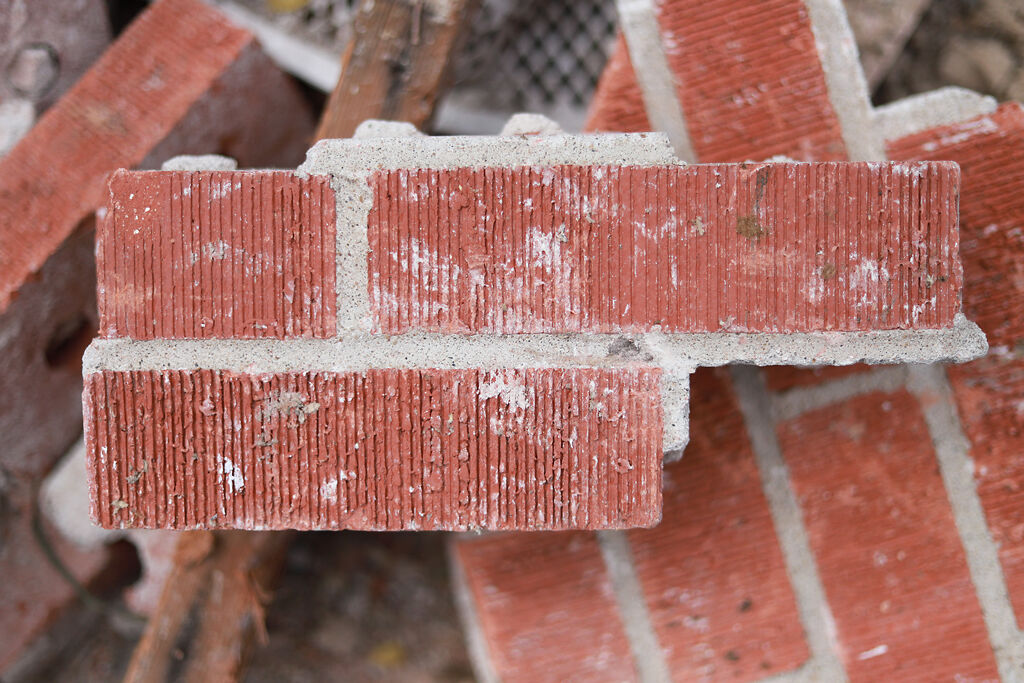 Red brick scatters across the rubble